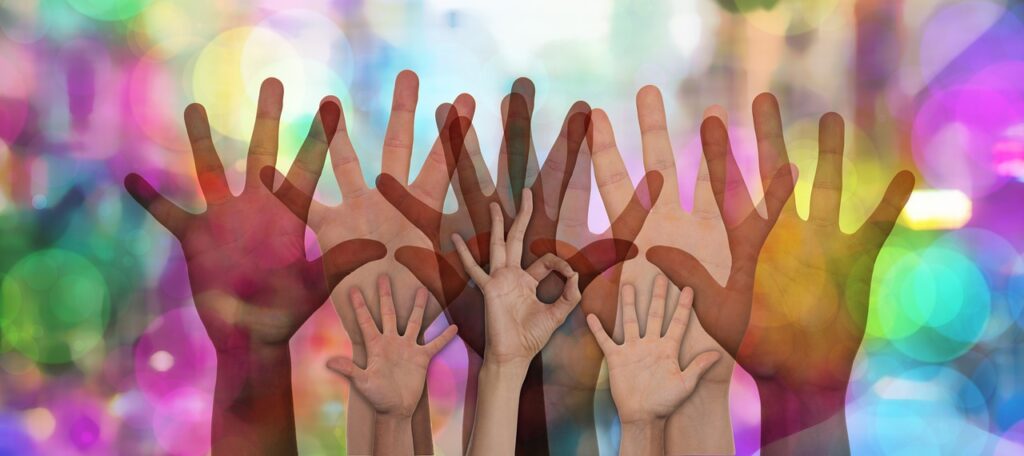 various raised hands on a multicolour background