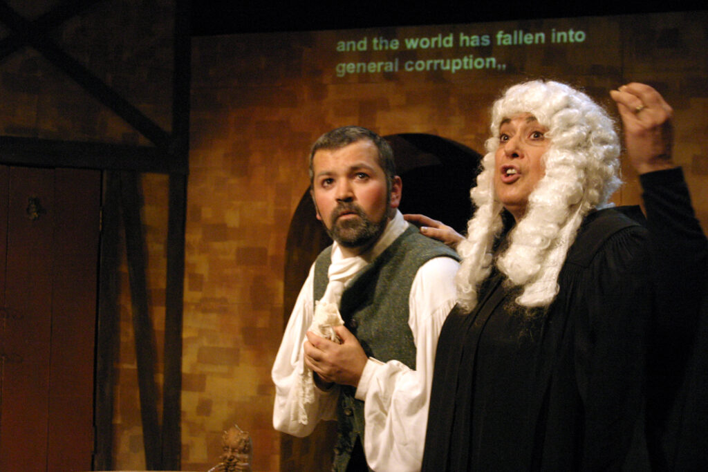 A man and a woman dressed as a judge perform in a play